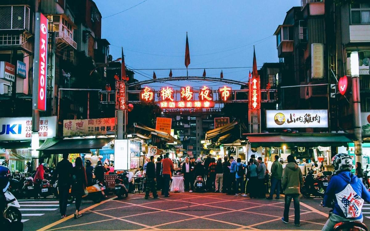 Cảnh chợ đêm Nanjichang Đài Bắc sầm uất, nhiều gian hàng ẩm thực đường phố và người đi bộ.